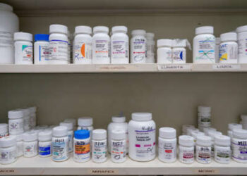 Los frascos de medicamentos se encuentran en el estante de una farmacia