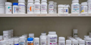 Los frascos de medicamentos se encuentran en el estante de una farmacia