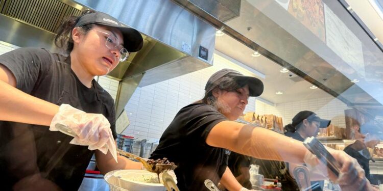 Los trabajadores completan pedidos de comida en un restaurante Chipotle en San Rafael, California, el 1 de abril de 2024. (Justin Sullivan/Getty Images)