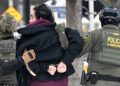 Federal agents detain a man as protestors demonstrate in Saint Paul, Minnesota, on January 8, 2026.
