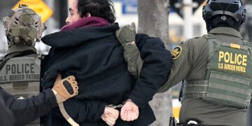 Federal agents detain a man as protestors demonstrate in Saint Paul, Minnesota, on January 8, 2026.